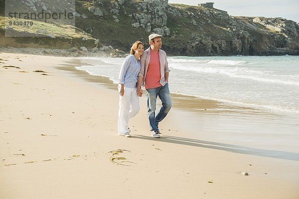Ein reifes Paar  das Händchen hält und am Strand spazieren geht  Camaret-sur-mer  Bretagne  Frankreich