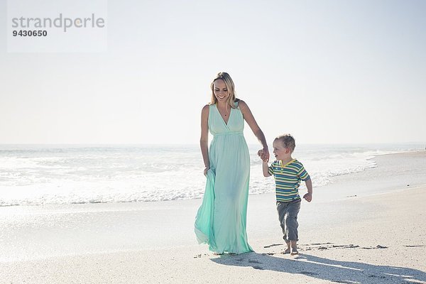 Mittlere erwachsene Mutter und junger Sohn halten Hände am Strand  Kapstadt  Westkap  Südafrika