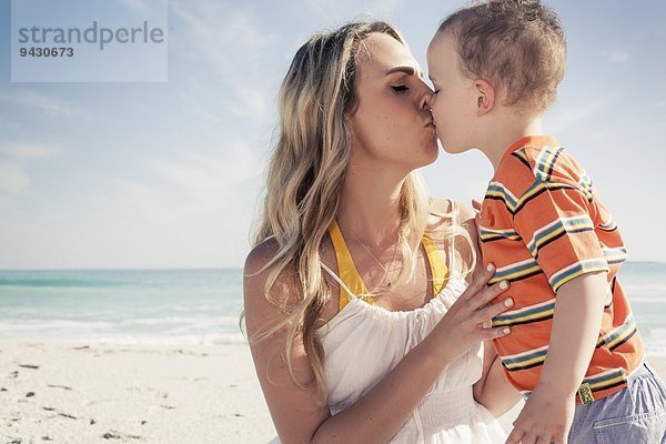 Mittlere erwachsene Mutter küsst jungen Sohn am Strand  Kapstadt  Westkap  Südafrika