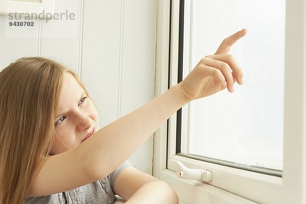 Mädchen  das aus dem Fenster der Ferienwohnung zeigt