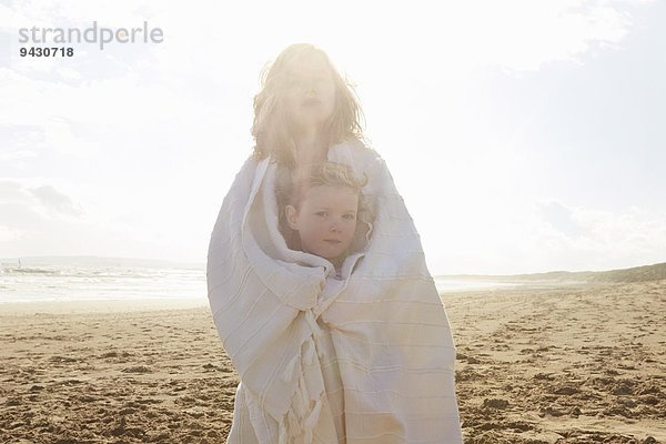 Portrait von zwei Schwestern in Decke am Strand  Camber Sands  Kent  UK