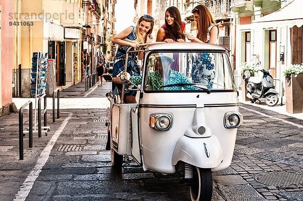 Drei junge Frauen auf dem offenen Rücksitz eines italienischen Taxis  Cagliari  Sardinien  Italien