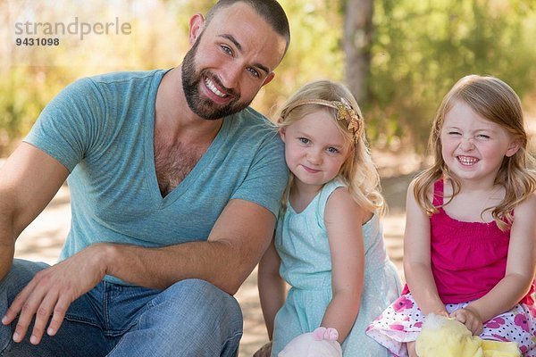 Porträt von Vater und zwei Töchtern im Park