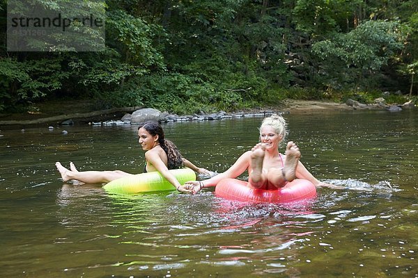 Frauen im Fluss mit aufblasbaren Ringen