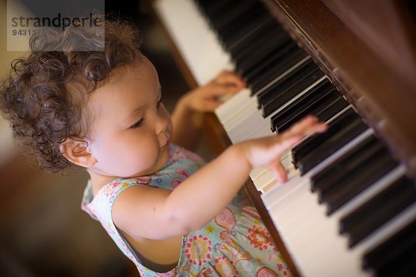 Süßes kleines Mädchen beim Klavierspielen