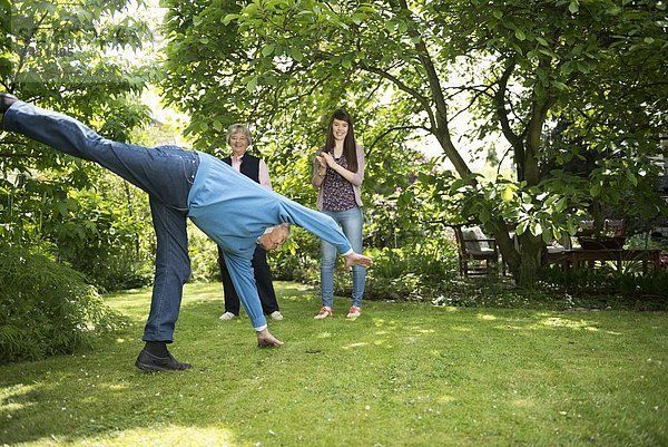 Großeltern und Enkelin bei der Gartenakrobatik