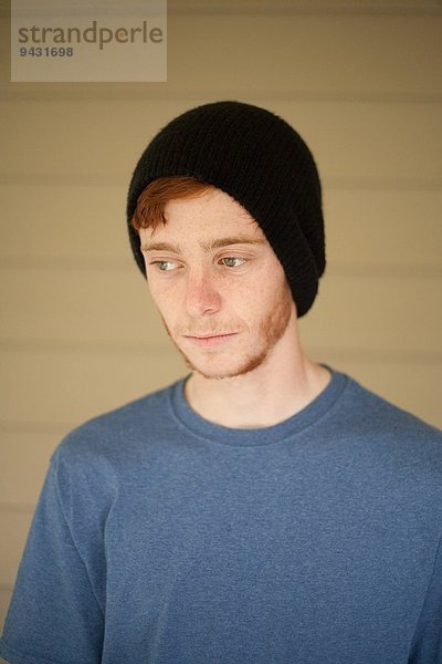 Porträt eines Teenager-Jungen mit Mütze  der zur Seite schaut