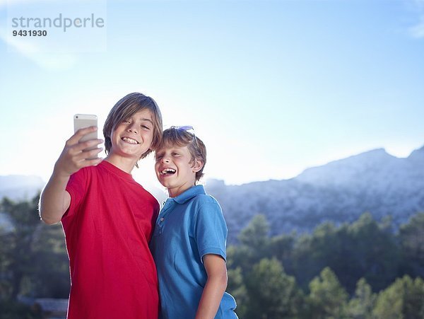 Zwei Brüder nehmen Selfie auf Smartphone  Mallorca  Spanien