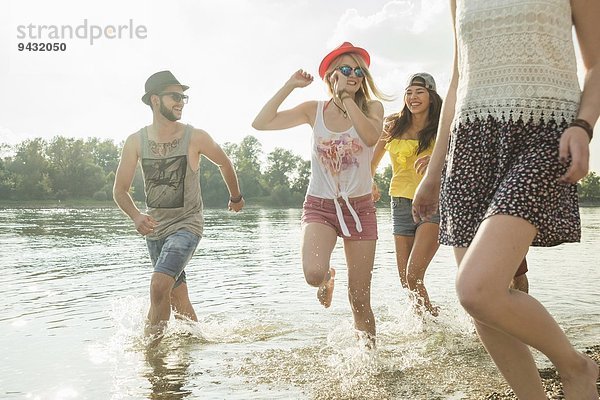 Gruppe junger Freunde beim Laufen im See