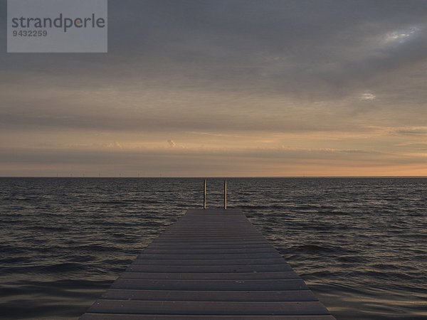 Seelandschaft mit Pier bei Sonnenaufgang