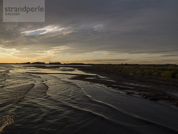 Meer und Silhouette der Küste bei Sonnenaufgang