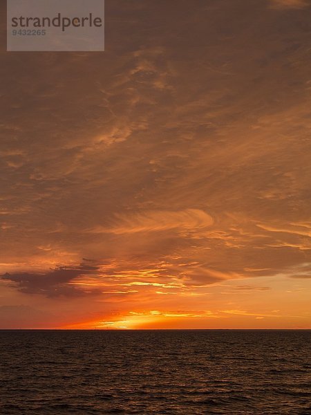 Seelandschaft mit Sonnenuntergang über dem Horizont