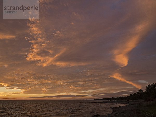 Meer und Silhouette der Küste bei Sonnenuntergang