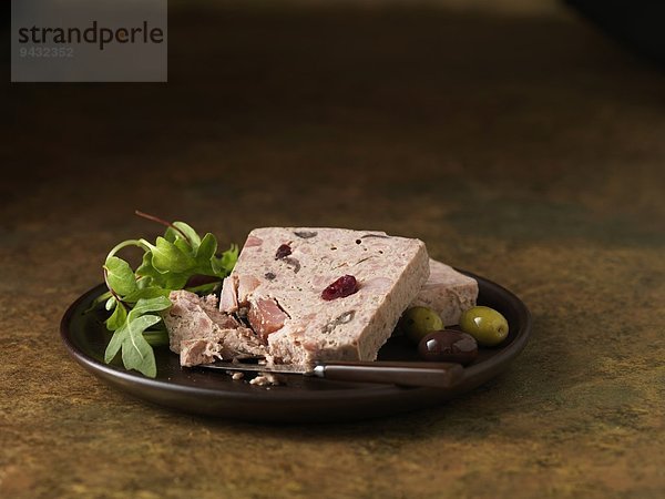 Weihnachtssnack aus geräuchertem Schinken  Truthahn und Hühnerterrine mit Preiselbeeren. Rucola gemischte Salatblätter mit grünen und schwarzen Oliven