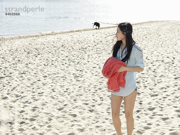 Junge Frau beim Bummeln am Strand mit Strandtuch  Port Melbourne  Melbourne  Victoria  Australien