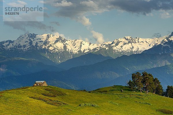 Scheune auf einem Hügel und entfernten schneebedeckten Bergen  Mazeri Dorf  Svaneti  Georgien