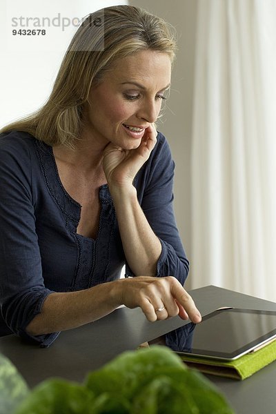 Reife Frau mit digitalem Tablett