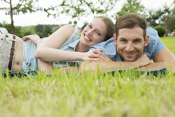 Mittleres erwachsenes Paar auf Gras liegend