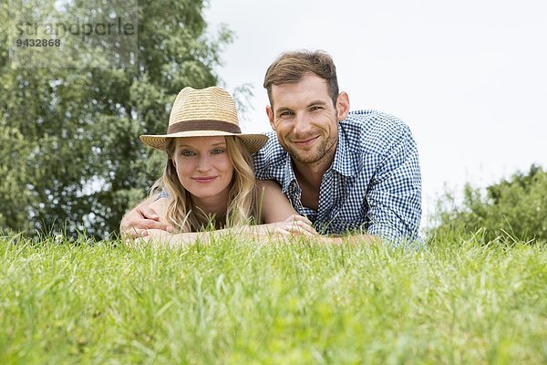 Mittleres erwachsenes Paar auf Gras liegend  Portrait