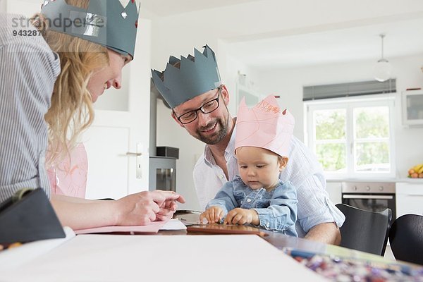 Eltern mit Baby-Tochter in hausgemachten Kronen