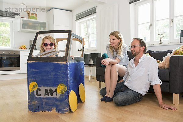 Eltern beobachten Tochter in hausgemachtem Spielzeugauto
