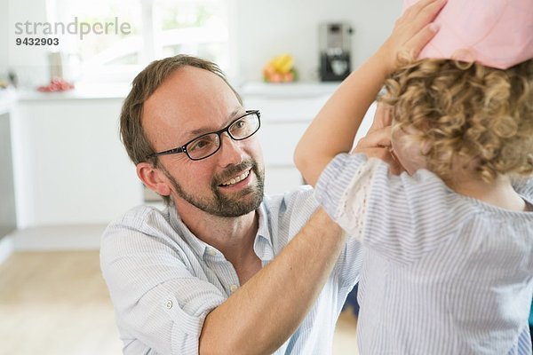 Mädchen versucht auf Papier Krone mit Vater