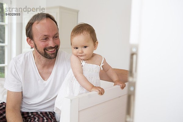 Vater lächelt kleine Tochter an