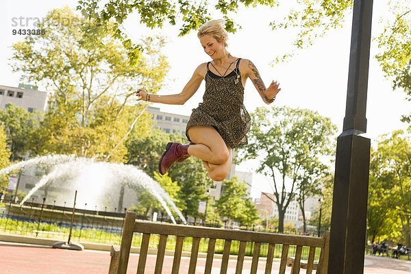 Junge Frau beim Springen in der Luft im Park
