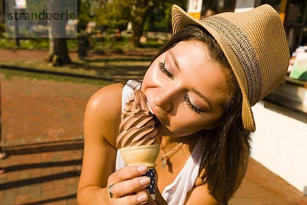 Junge Frau beim Eis essen im Park