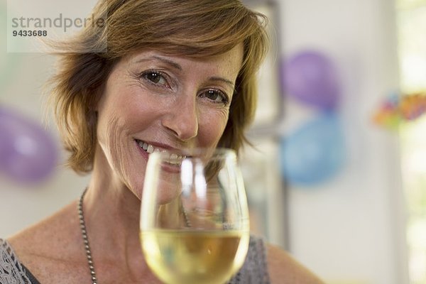 Porträt einer reifen Frau mit einem Glas Wein