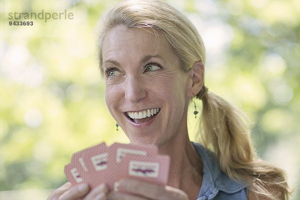 Reife Frau beim Kartenspielen