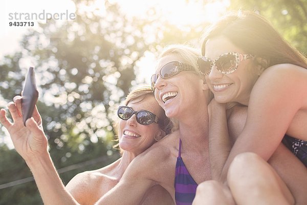 Drei reife Frauen in Badebekleidung  die sich selbst porträtieren.