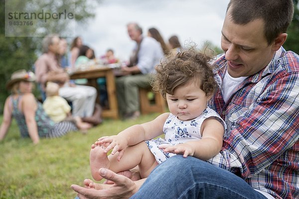 Vater spielt mit Tochter beim Familientreffen  im Freien