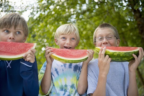 Freunde essen Wassermelone im Garten