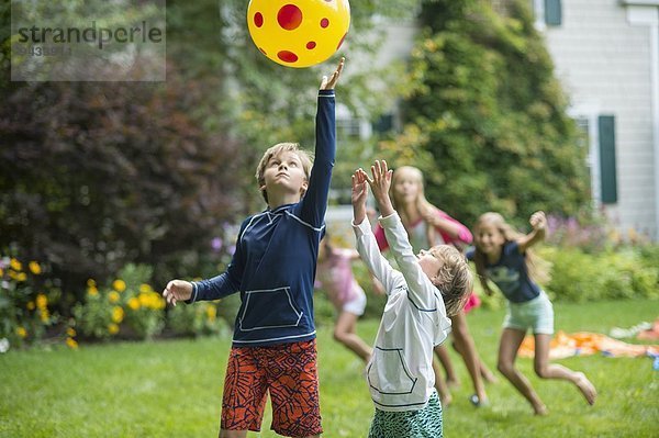 Kinder beim Ballspielen im Garten