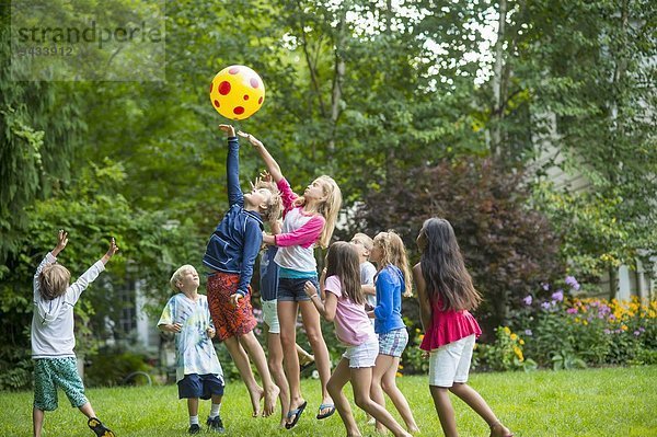 Kinder beim Ballspielen im Garten