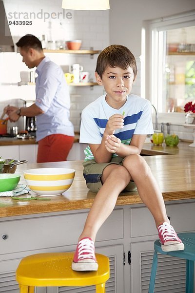 Junge sitzt auf der Küchentheke
