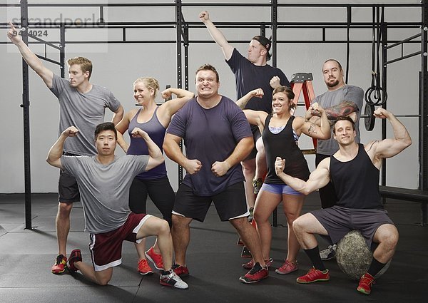 Porträt von acht Crossfit-Kollegen  die sich im Fitnessstudio bewegen