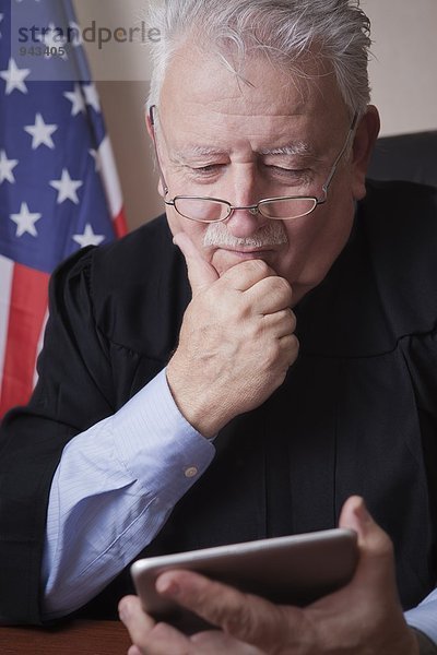 Senior Richterin beim Lesen von digitalen Tabletts