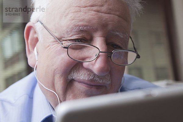 Senior Mann liest digitales Tablett