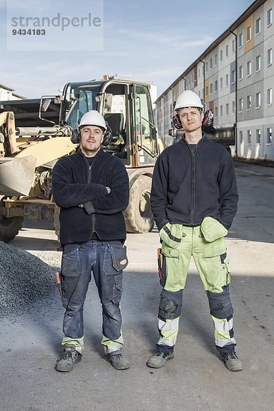 Vollständiges Porträt der selbstbewussten Arbeiter auf der Baustelle