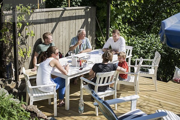 Familie und Freunde beim Frühstück im Hof
