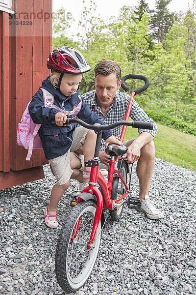 Vater assistiert Tochter beim Radfahren