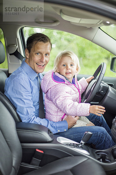Porträt eines glücklichen Vaters und einer glücklichen Tochter im Auto