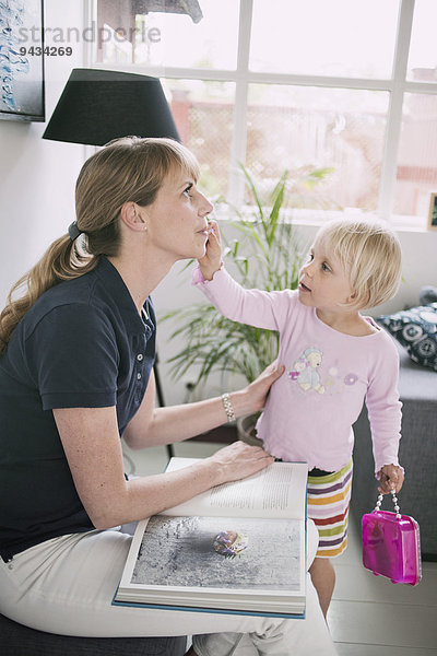 Mädchen beim Schminken der Mutter zu Hause