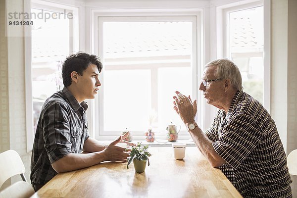 Seitenansicht des Großvaters und des Enkels beim Kaffeetrinken