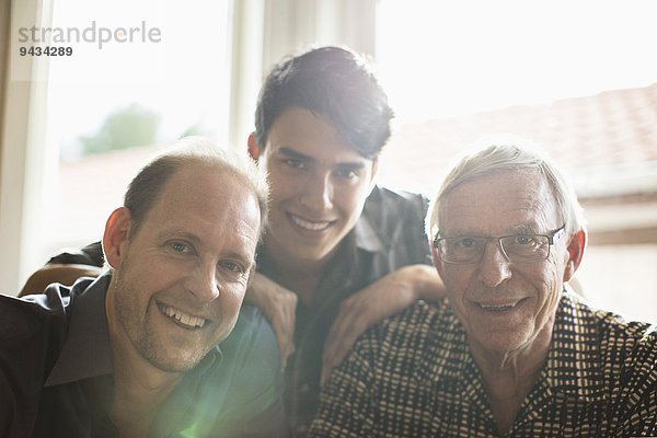 Porträt einer Drei-Generationen-Familie  die zu Hause zusammen lächelt