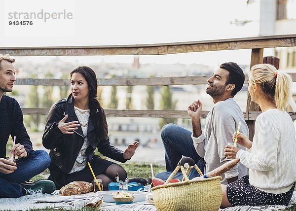 Multi-ethnische Freunde genießen Party im Dachgarten