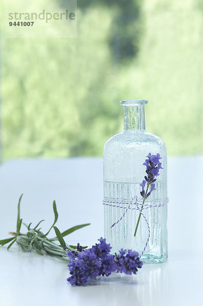 Lavendelblüte und Lavendelwasser in einer Glasflasche