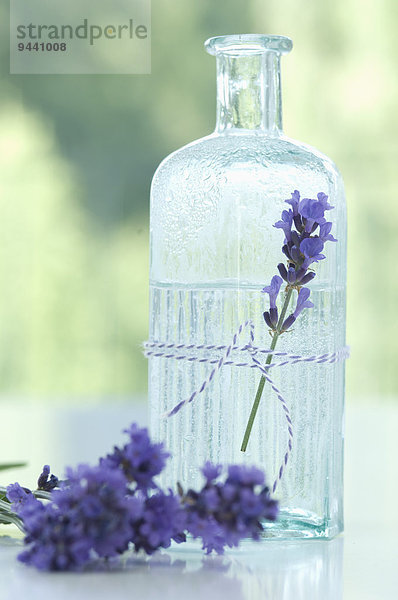 Lavendelblüte und Lavendelwasser in einer Glasflasche